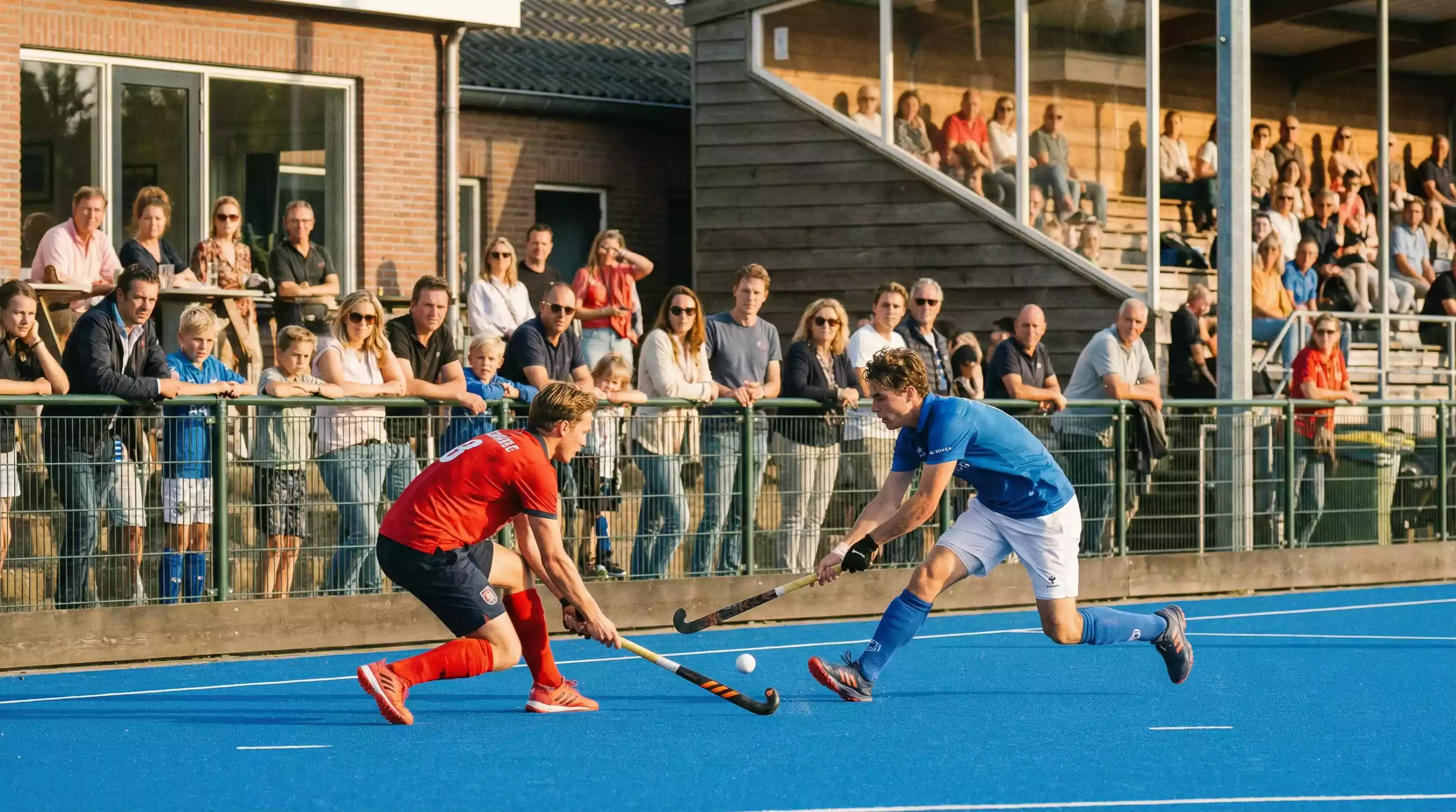Hockeywedstrijd in de Hoofdklasse met publiek op de tribune