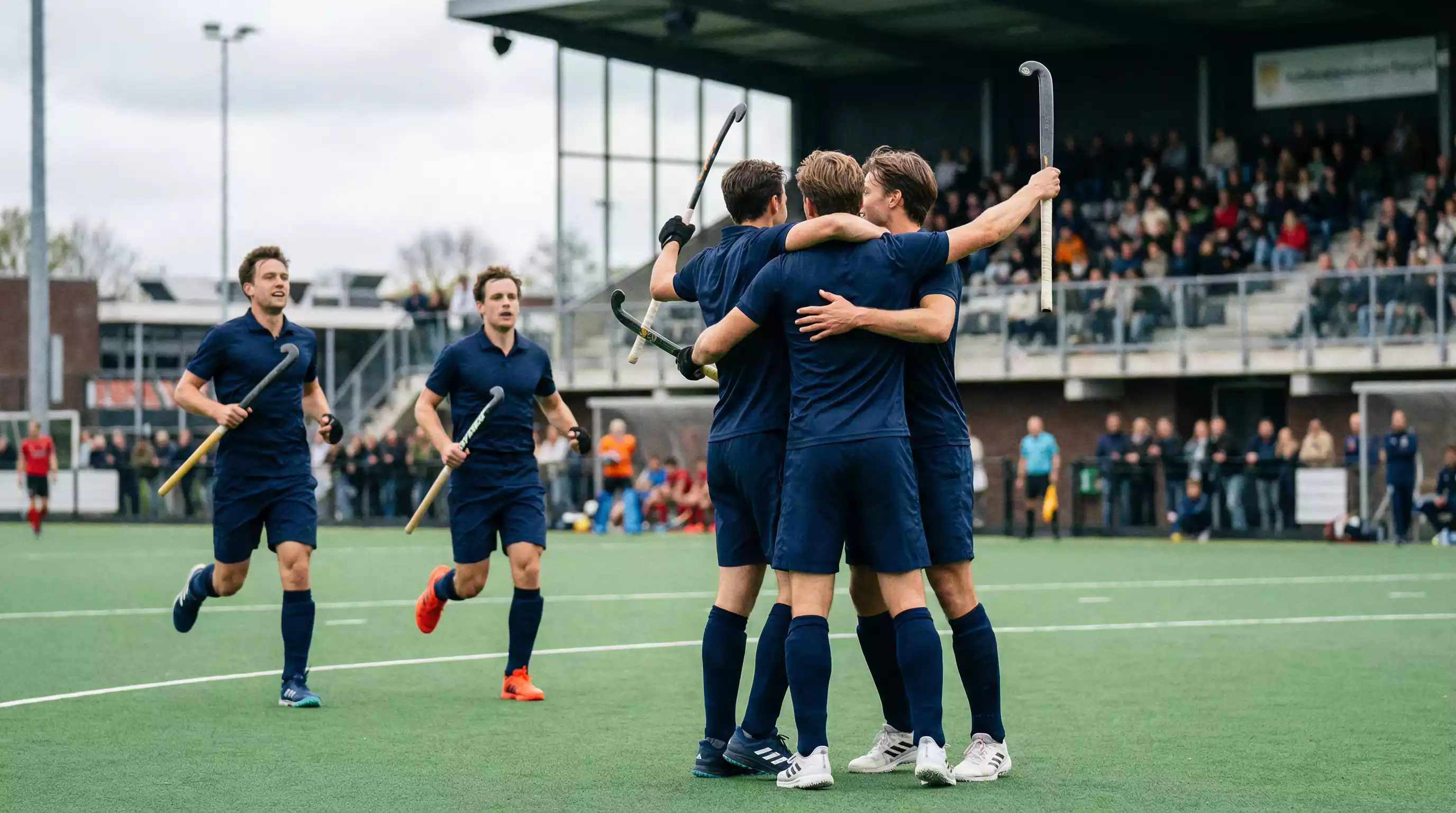 Hockeyspelers van een topclub vieren een doelpunt op het veld
