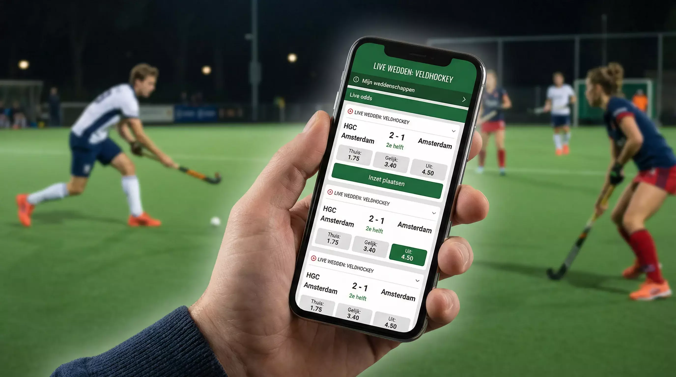 Smartphone met sportweddenschap app in de hand van een persoon die naar een hockeywedstrijd kijkt
